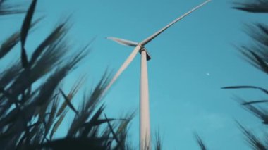 Windmill with propeller against blue sky view from wheat