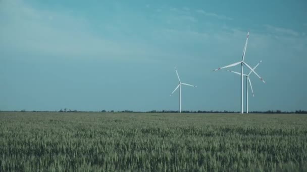 Wind turbines with propellers produce electricity in field — Stock videók
