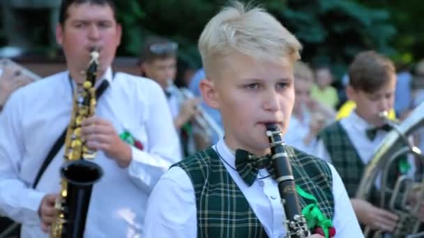 Ungdomar i gröna festliga kostymer spelar flöjter på gatan — Stockvideo