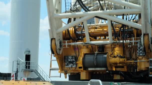 Yellow crane with windlass stands near tower of windmill — Stock videók