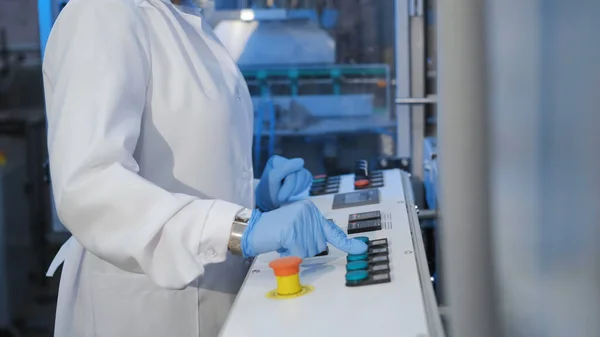 Kadın üretim ekipmanında bir düğmeye basıyor