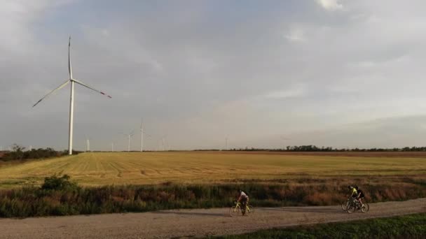 Jízda na kole po venkovské silnici kolem pole s větrnými mlýny — Stock video