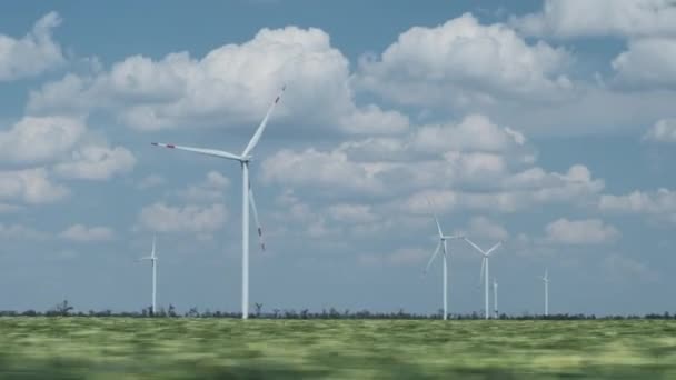 Generátory poháněné větrem s otočnými lopatkami v zeleném poli — Stock video