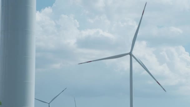 Las turbinas eólicas generan electricidad contra nubes esponjosas — Vídeo de stock
