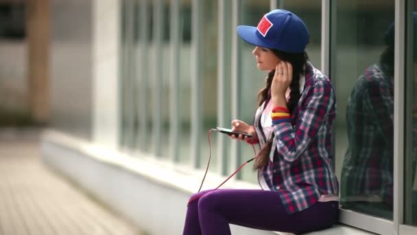 Flicka som lyssnar på musik på en mobiltelefon — Stockvideo