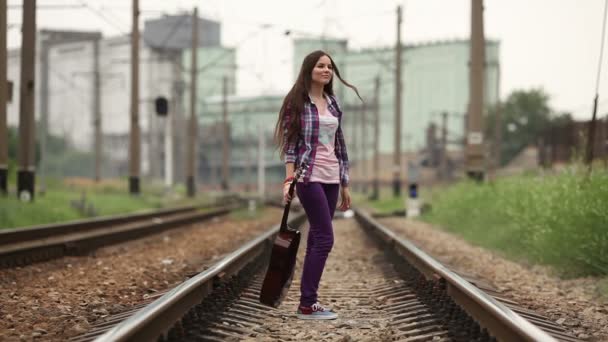 Girl walking on railway wish guitar — Stock Video