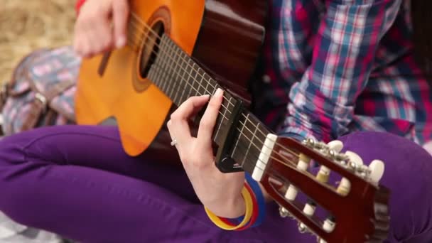 Flickan komponerar musik med en gitarr. — Stockvideo