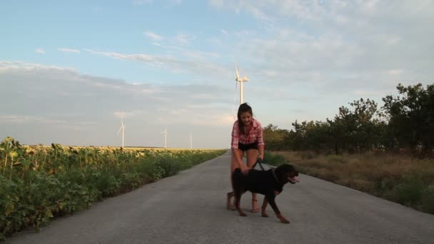 Una giovane ragazza cammina con un cane . — Video Stock