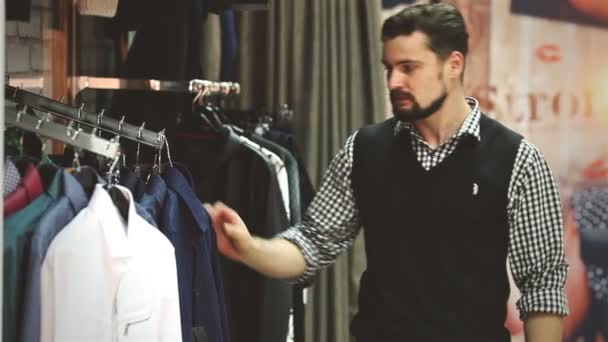 Porträtt av en ung man shopping för kläder i butik — Stockvideo