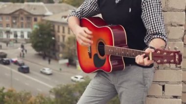 Adam çatıda bir gitar ile