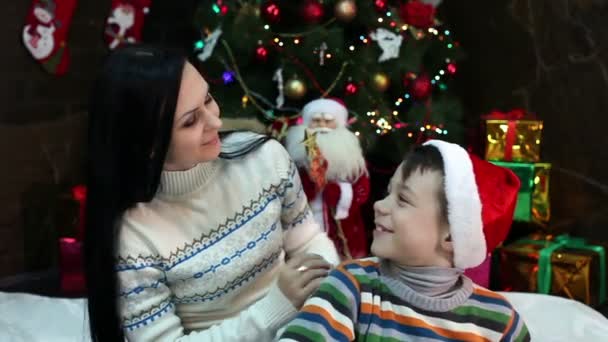 Ano Novo. No Natal. Mãe e filho perto da árvore de Natal e lareira. Casa acolhedora, clima de Natal . — Vídeo de Stock