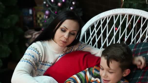 Año Nuevo. Navidad. Mamá e hijo cerca del árbol de Navidad y la chimenea. Acogedora casa, humor navideño . — Vídeos de Stock