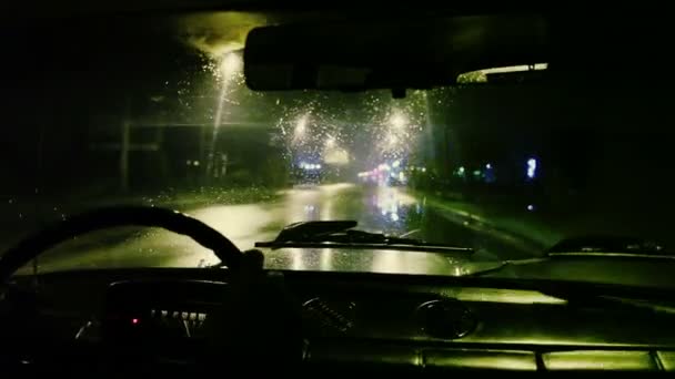 El hombre se sienta en el coche, de cerca. Noche-noche en tiempo lluvioso, captura en tiempo real, vista interior, panel de control, rueda, gran angular — Vídeos de Stock