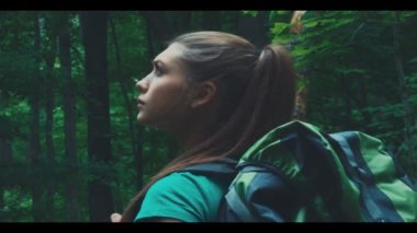 Uzun yürüyüşe çıkan kimse kadın ormanda, hiking durur ve etrafına bakıyor.