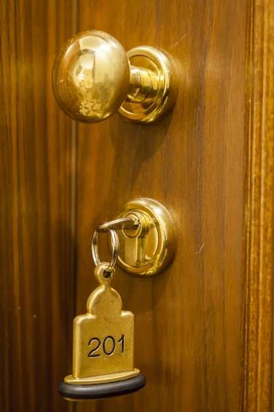 Hotel rumsnyckel liggande på sängen med nyckelring — Stockfoto
