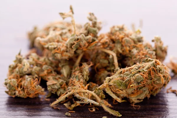 Закрыть сухие листья марихуаны на столе — стоковое фото