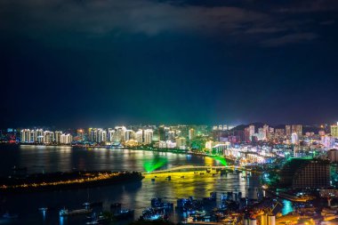 Sanya Körfezi 'nin gece görüşü şehir ışıklarıyla aydınlandı. Çin 'in Hainan Adası' ndaki Luhuitou Parkı 'ndan görüntü.