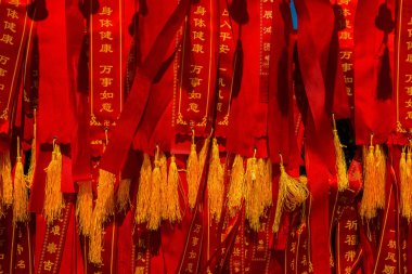 HANA ADASI, ÇİN - 27 Kasım 2016: Nanshan tapınağında dilekleri asılı bir sürü geleneksel Çin kırmızı kurdelesi.