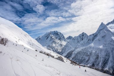 Mt. Mussa-Achitara kayak pisti. Kış güneşli bir günde Dombay-Ulgen ve Ine ufukta belirdi. Dombai kayak merkezi, Karachai-Cêess, Batı Kafkasya, Rusya.