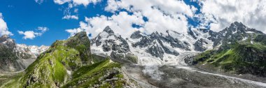 Kafkasya 'nın kar örtüsü zirvelerinin ve dibindeki buzulun yaz manzarası. Rusya, Kabardino-Balkaria, Elbrus bölgesi.