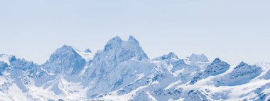 Panoramic view of a snowy winter Greater Caucasus mountains at sunny day. Mt. Elbrus, Kabardino-Balkaria, Russia clipart