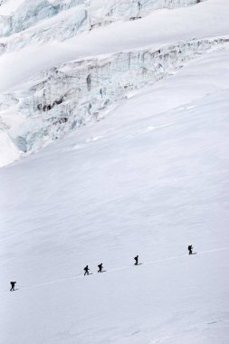 Bir grup dağcı Elbrus yamacındaki Gara-Bashi buzulunu geçiyor..