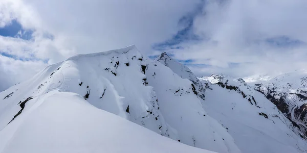 Snow cornice near Mount Cheget summit with snowboard track