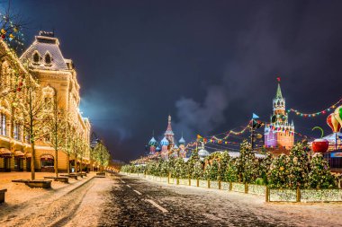Kızıl Meydan Noel süslemesinde. Saint Basil Katedrali, üst hatlar (GUM mağazası) ve kış gecelerinde Spasskaya Kulesi. Moskova, Rusya.