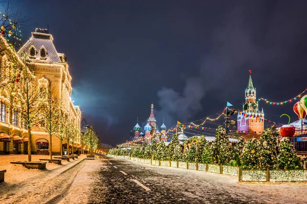 Kızıl Meydan Noel süslemesinde. Saint Basil Katedrali, üst hatlar (GUM mağazası) ve kış gecelerinde Spasskaya Kulesi. Moskova, Rusya.