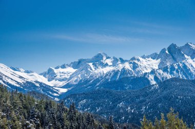 Kış güneşli bir günde kar Kafkasya dağlarını kapladı. Kayak pistinden görüntü. Arkhyz kayak merkezi, Rusya.