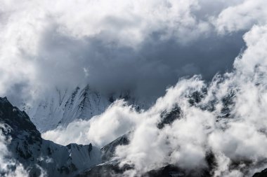 Himalaya dağlarının tepeleri kar ve bulutlarla kaplı.