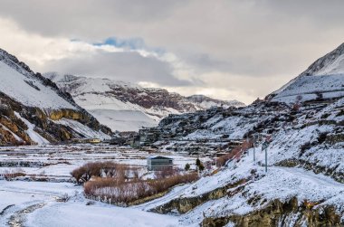 Kali Gandaki nehir vadisi ve eski Kagbeni köyü kar yağışından sonraki kış bulutlu. Kagbeni 'den Jomsom' a yürüyüş güzergahından görünüm.
