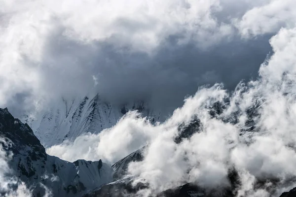Himalaya dağlarının tepeleri kar ve bulutlarla kaplı.