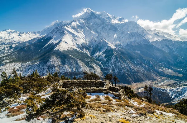 山に対して岩の山の斜面に廃墟の家 晴れた冬の日にニルギ Yak Kharka Ananapurna Circuit Jomson Treak Nepal — ストック写真