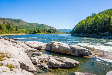 Sibirya dağ nehri Küçük Yenisei yaz güneşli bir günde. Kayalık nehir kıyısında büyük taşlar.