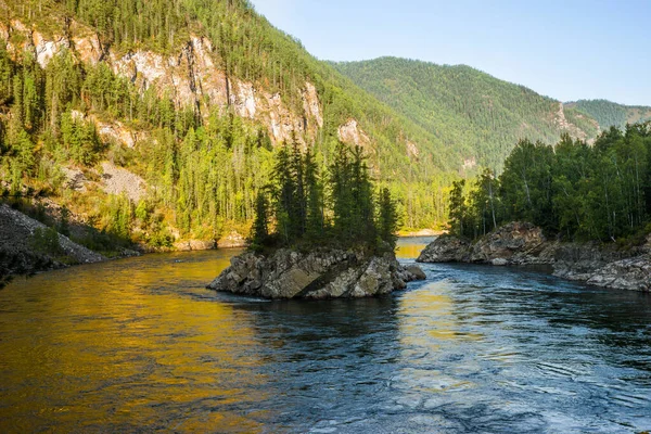 Yazın güneşli bir sabahta ağaçlarla kaplı Rocky Adası. Dağ nehirleri Balyiktyig hem ve Kyzil hem, Sibirya, Rusya.