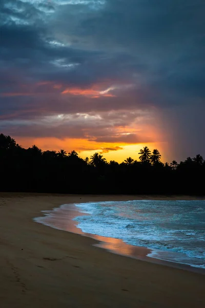 Dark stormy clouds and rain over the wild beach in Unawatuna, Sri Lanka.