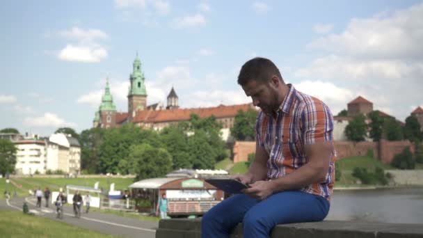 Man takes a selfie, sitting on the wall. — Stock Video