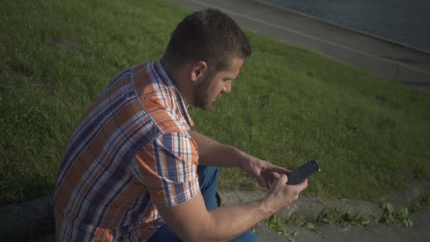 Muž volání telefon u řeky. — Stock video