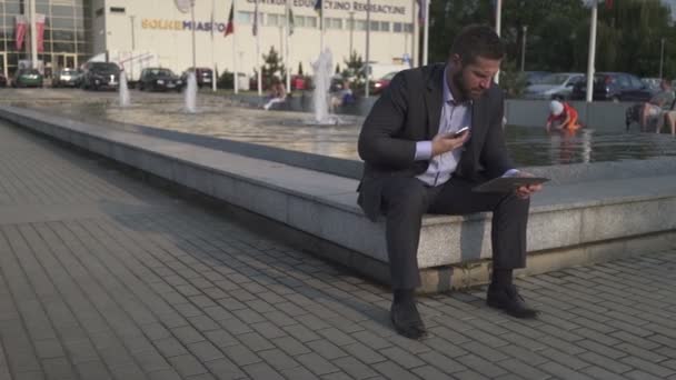 Homme d'affaires navigation tablette, répond smartphone . — Video