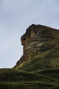 Gum-bashi dağ geçidi üzerinde dikey manzara, uçurumlarda yeşil ve çimenler, fırtınadan önce kara bulutlar, aucasus dağ sıraları ve Elbrus dağı. Karachay-Çerkessia