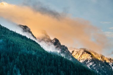Gün batımında, Arkhyz köyü, Kafkasya dağları, Rusya, Arkhyz köyü boyunca dağ tepeleri ve renkli bulutlar karla kaplıydı.