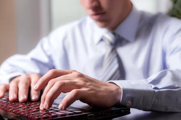 Primo piano mani di un giovane uomo che lavora con entusiasmo sulla co Foto Stock