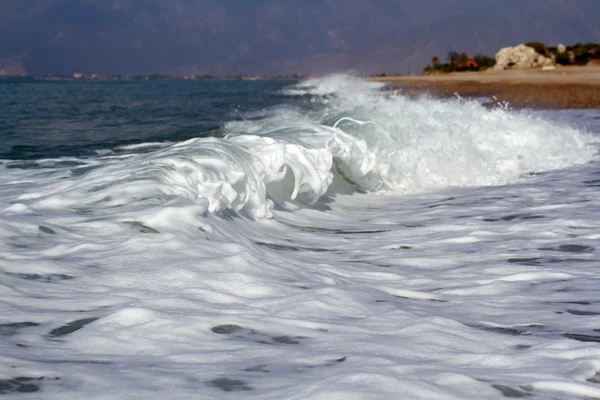 Onde schiumose del mare che lambiscono la riva . — Foto Stock