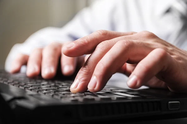 Primeros dedos de hombre en un teclado de computadora . Fotos de stock libres de derechos
