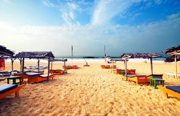 Strandon fekvő napágyakkal és napernyőkkel. Stock Kép