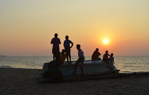 Srí-Lanka, Negombo, 2016. január 10., háttérvilágítás fiúk a tükrözött hajón. Háttérvilágítás Jogdíjmentes Stock Képek