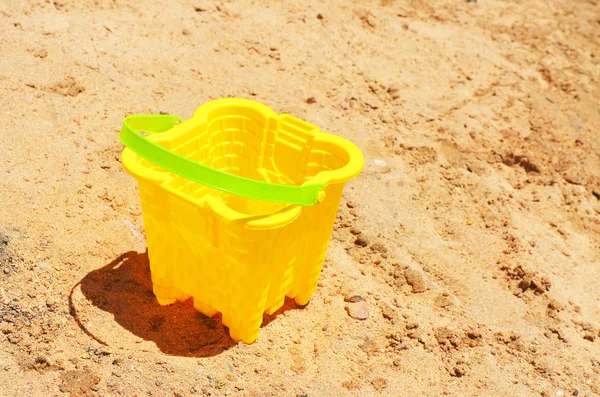 Children yellow bucket bucket on the sand — Stok fotoğraf