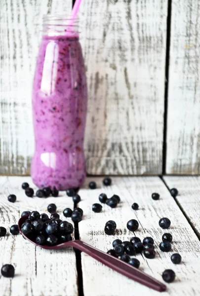 Blueberry smoothie på flaska på den vita trä bakgrunden — Stockfoto
