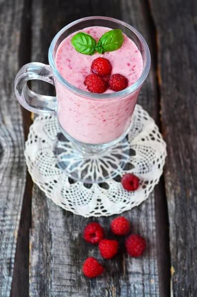 Hallon smoothie i glas med bär på vintage servetten på trä bakgrund — Stockfoto